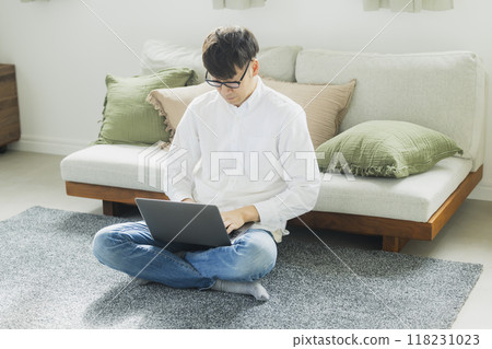 一個人在客廳裡使用個人電腦 一個人在客廳裡使用個人電腦 118231023