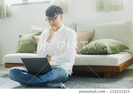 A man who uses a personal computer in the living room 118231025