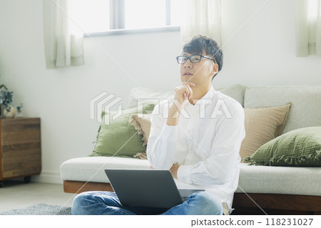 一個人在客廳裡使用個人電腦 118231027