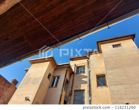 Architectural detail, of old urban building wall against blue sky Architectural detail, of old urban building wall against blue sky 118231260
