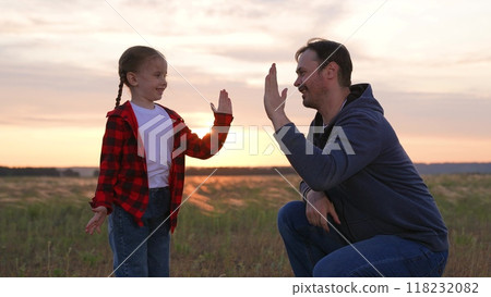 Daughter father special handshake greeting clapping hands gesture expressing strong close family relationship. Baby girl kid child man dad at sunset sunrise in field happy relatives hugging cuddling. Daughter father special handshake greeting clapping hands gesture expressing strong close family relationship. Baby girl kid child man dad at sunset sunrise in field happy relatives hugging cuddling. 118232082