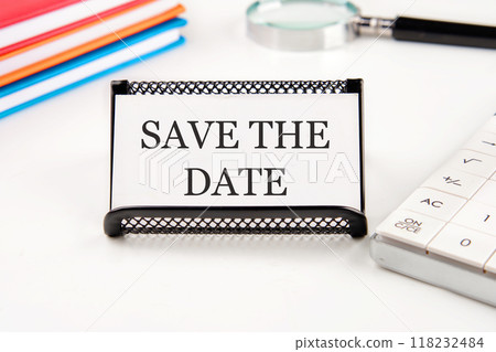 SAVE THE DATE words on a business card in a composition with a magnifying glass, notebooks, a calculator on a white background SAVE THE DATE words on a business card in a composition with a magnifying glass, notebooks, a calculator on a white background 118232484
