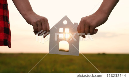 hands holding paper house, window sunset ray, happy family mortgage build new house, building a new home, fixing credit for mortgage, moving day essentials, downsize your home, kerb appeal 118232544
