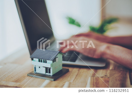 房屋模型和在電腦上工作的人的手 118232951