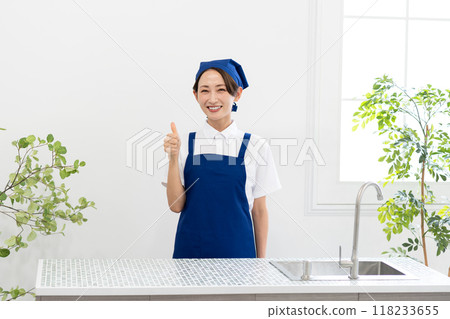 A woman working as a housekeeping service in an apron 118233655