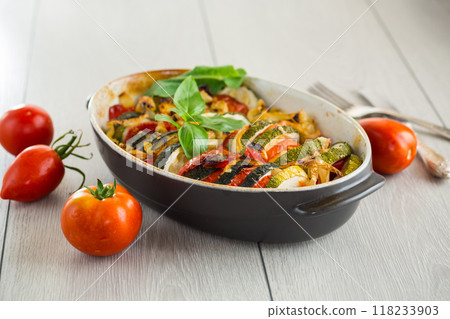 prepared baked zucchini and tomatoes in circles in a ceramic form, vegetable snack 118233903