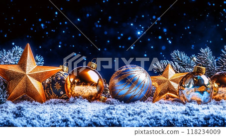 Gold and blue Christmas decorations with stars and pine branches on snowy ground under starry night sky. 118234009