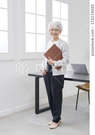 微笑的老年女商人站在辦公室，全身 118234888