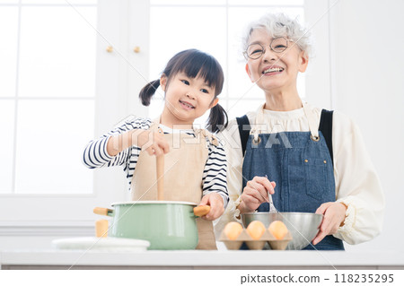 Girl and senior woman standing in the kitchen Cooking image 118235295