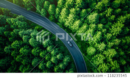 A car driving on a winding forest road surrounded by green trees on a sunny day. Generative AI 118235545