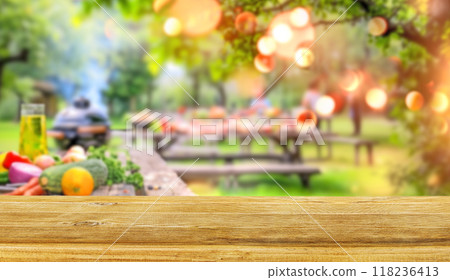 summer time party in backyard garden with grill BBQ and vegetables, wooden table, blurred background 118236413