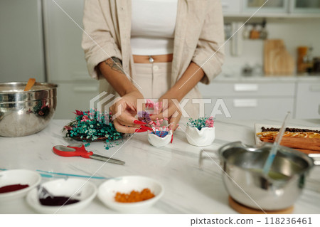 Woman Decorating Handmade Candles At Table Woman Decorating Handmade Candles At Table 118236461