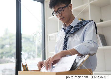Businessman Packing Personal Belongings in Office After Resignation or Job Loss 118236913