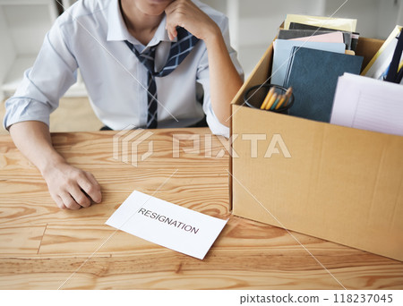 Disappointed Businessman Holding Resignation Letter and Packing Belongings Disappointed Businessman Holding Resignation Letter and Packing Belongings 118237045