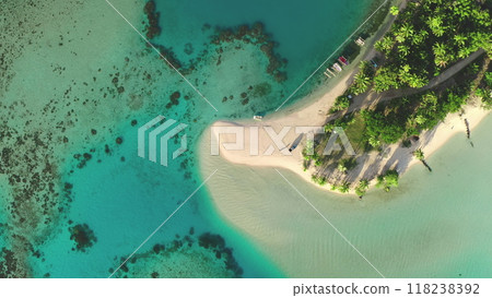 Aerial view top down small tropical island with palm trees and white sand beach surrounded by turquoise ocean water and coral reef. Remote wild nature paradise, exotic summer luxury travel. Drone shot 118238392