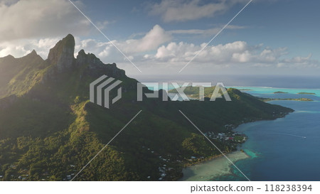 Golden sunlight over iconic mountain peak and turquoise lagoons of Bora Bora tropical island, dramatic beauty of French Polynesian paradise. Remote wild nature scene, travel background. Aerial view 118238394
