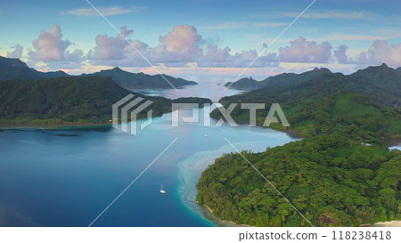 Tourist yacht in tropical ocean bay surrounded by lush green islands in French Polynesia, beautiful sunset sky in background. Remote wild nature paradise, exotic summer luxury travel. Aerial view Tourist yacht in tropical ocean bay surrounded by lush green islands in French Polynesia, beautiful sunset sky in background. Remote wild nature paradise, exotic summer luxury travel. Aerial view 118238418