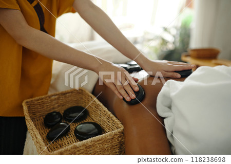 Performing Hot Stone Massage in Tranquil Environment 118238698