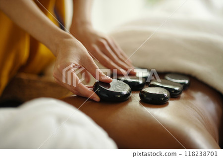 Relaxing Hot Stone Massage Therapy in Spa Setting Relaxing Hot Stone Massage Therapy in Spa Setting 118238701