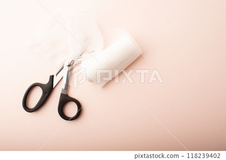 Scissors and bandage on pink background top wiev. Treatment wounds. Applying plaster to the fracture. Medical concept banner. Healthcare banner. Copy space. High quality photo 118239402