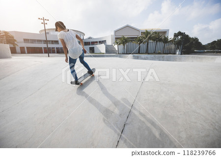 Skateboarder skateboarding at skatepark in city Skateboarder skateboarding at skatepark in city 118239766
