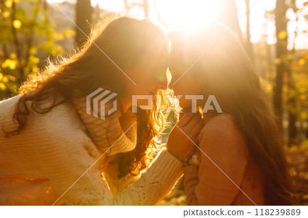 Portrait of happy mother and daughter in autumn forest at sunset. . Autumn women. 118239889