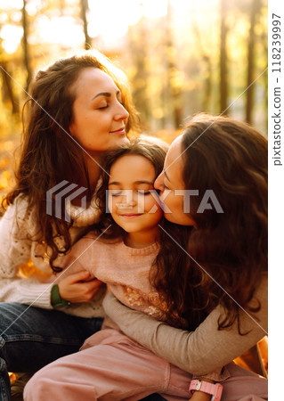 The homosexual family playing with her daughter in the autumn forest. The adventure is more fun. The homosexual family playing with her daughter in the autumn forest. The adventure is more fun. 118239997