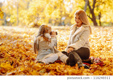 Young Mother and daughter walking in the park and enjoying the beautiful autumn nature. Walk, family 118240311