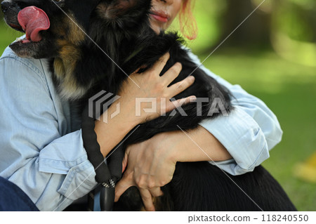 Loving young woman cuddling her dog showing affection, companionship, trust and care 118240550