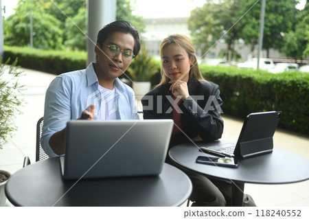 Young business colleagues discussing project results at outdoor cafe 118240552