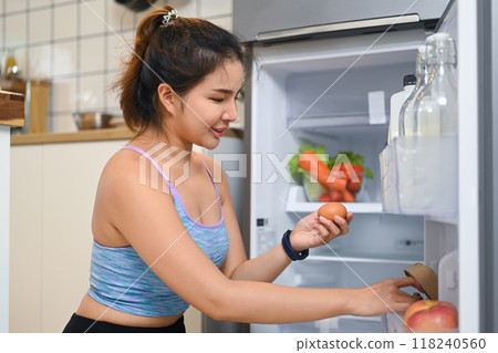 Young woman searching for ingredients while preparing a meal or snack Young woman searching for ingredients while preparing a meal or snack 118240560