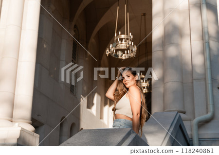 Woman, Chandelier, Building - Portrait of a woman standing in the doorway of a building with a chandelier hanging overhead. 118240861