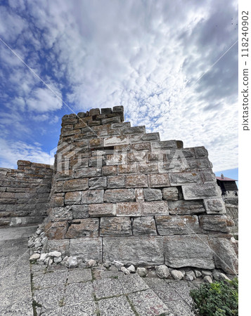 a adobe and stone wall with picturesque house 118240902