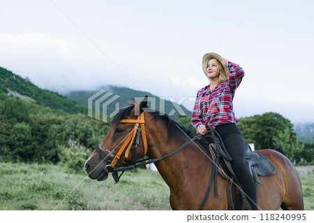 A woman is riding a horse in a field 118240995