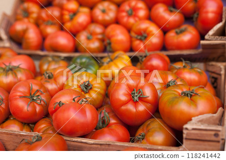 Fresh tomatoes on branch in wicker baskets on counter Fresh tomatoes on branch in wicker baskets on counter 118241442