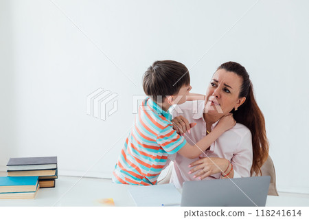 Boy son distracts mom from working with laptop Boy son distracts mom from working with laptop 118241614