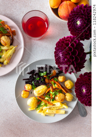 Enjoy a healthy and delicious breakfast or lunch featuring baked vegetables such as potatoes, zucchini, carrots, and beets, complemented by fresh fruits and cherry compote 118242974