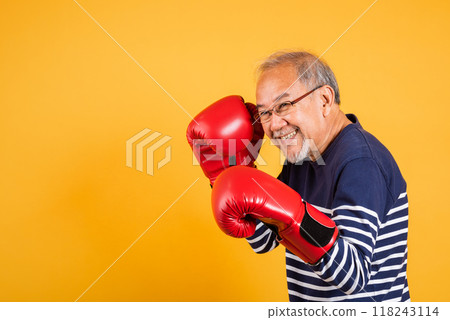 Portrait Asian old man wearing glasses wear two red boxing gloves studio shot isolated yellow background, smiling happy elderly man gray haired healthy fighter lifestyle concept Portrait Asian old man wearing glasses wear two red boxing gloves studio shot isolated yellow background, smiling happy elderly man gray haired healthy fighter lifestyle concept 118243114
