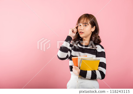 Portrait of beautiful Asian young woman teenage smiling hugging books, female person holding book and thinking idea, studio shot isolated on pink background with copy space, education concept 118243115