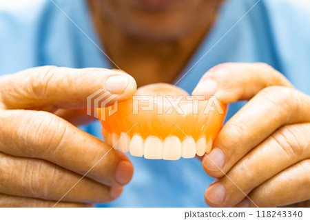 Asian elderly woman patient holding to use denture, healthy strong medical. Asian elderly woman patient holding to use denture, healthy strong medical. 118243340