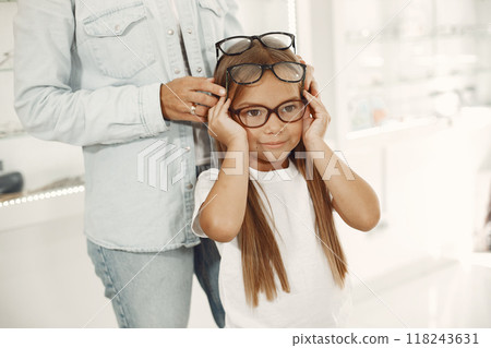 Mother with daughter. People in the store. Child in a white t-shirt. Mother with daughter. People in the store. Child in a white t-shirt. 118243631
