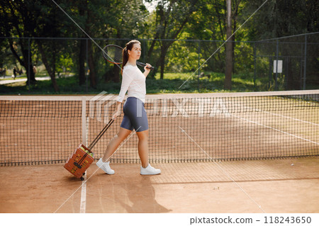 Tennis player going through tennis curt. Model posing. Hobbies, sports, equipment. Tennis player going through tennis curt. Model posing. Hobbies, sports, equipment. 118243650