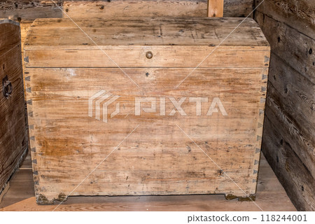 Old wooden chest against wooden wall 118244001