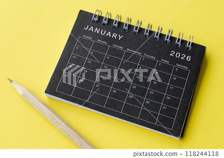 Top view of January 2026 calendar on black notepad with yellow background. New Year and Calendar concept 118244118