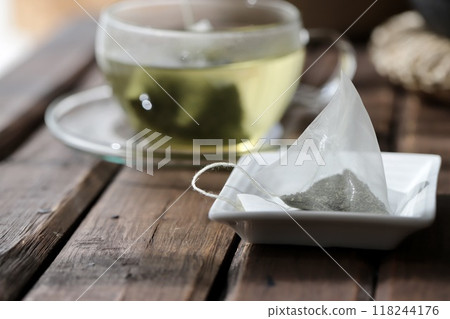 Hot green tea brewed in a triangular tea bag Hot green tea brewed in a triangular tea bag 118244176