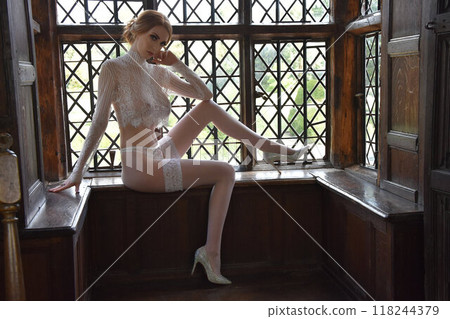 Beautiful girl in lace, posing in the window of an old house 118244379