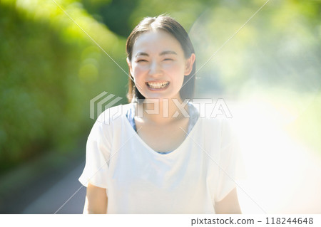 穿著運動服行走的微笑的年輕女子 穿著運動服行走的微笑的年輕女子 118244648