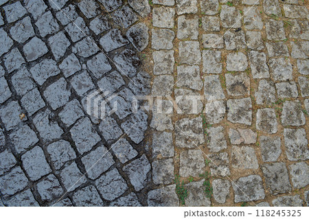 Porto, Portugal - 2024, September 1: Close-up of old paving stones, half of which are prepared for asphalt pouring. Concept of repair works in old historical cities, urban development technologies, Porto, Portugal - 2024, September 1: Close-up of old paving stones, half of which are prepared for asphalt pouring. Concept of repair works in old historical cities, urban development technologies, 118245325