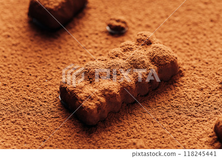 Close-up of chocolate truffle covered in cocoa powder, creating a rich and textured dessert scene 118245441