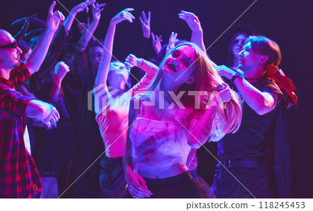 Young people, boys and girls, in diverse Halloween costumes, from ghosts to fairies, dancing at nightclub, celebrating, laughing and having fun 118245453